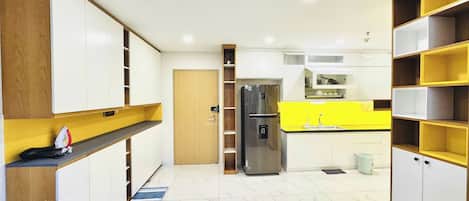 A modern kitchen with white cabinetry, a stainless steel refrigerator, and a yellow countertop.