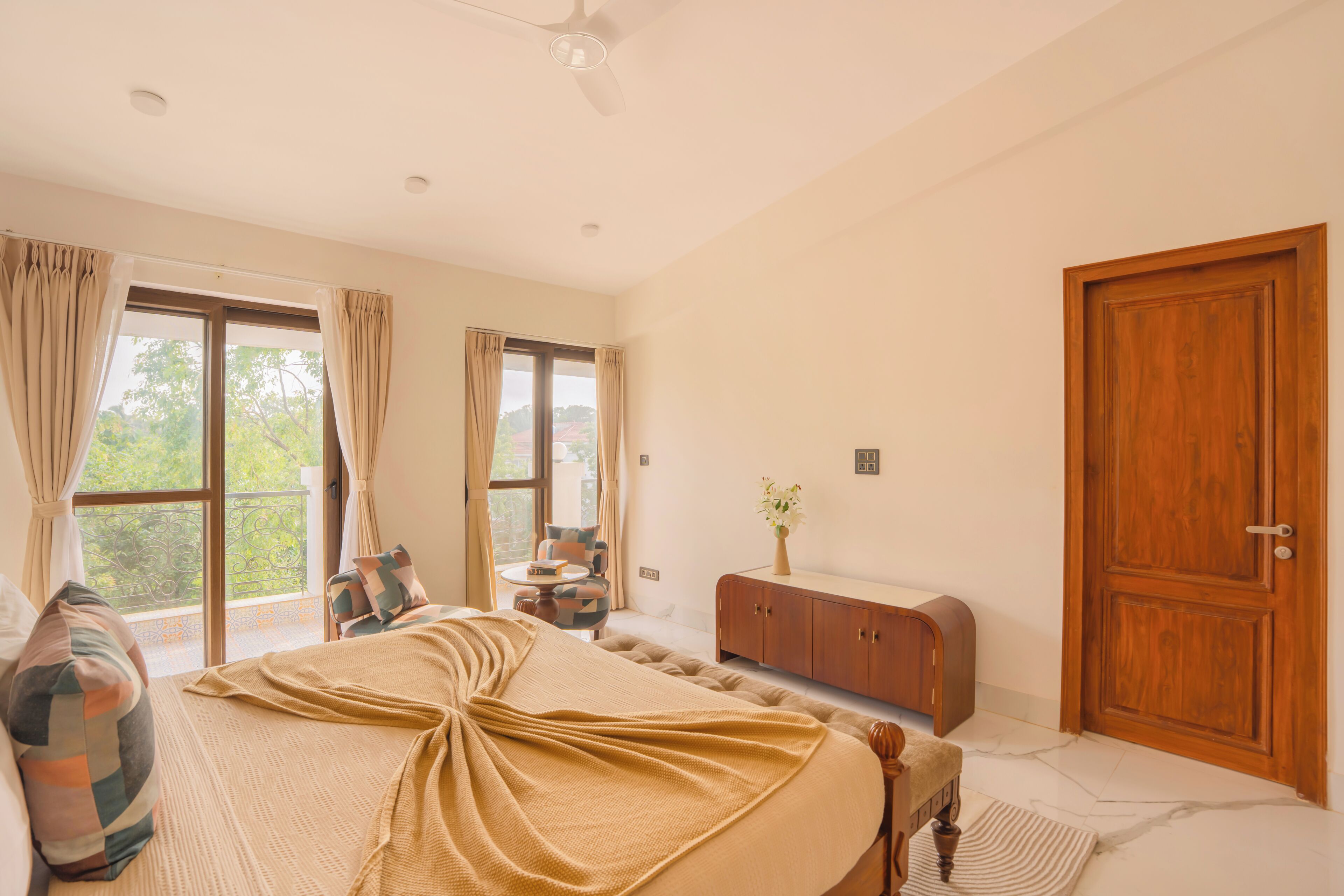 Een slaapkamer met een bed, een houten kast, een bureau en een raam met gordijnen.