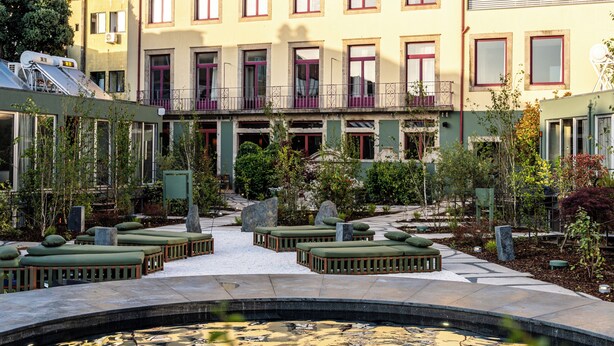 A courtyard with a pool, surrounded by buildings with balconies and windows. - chic&basic Tokyo Hoose (Porto)