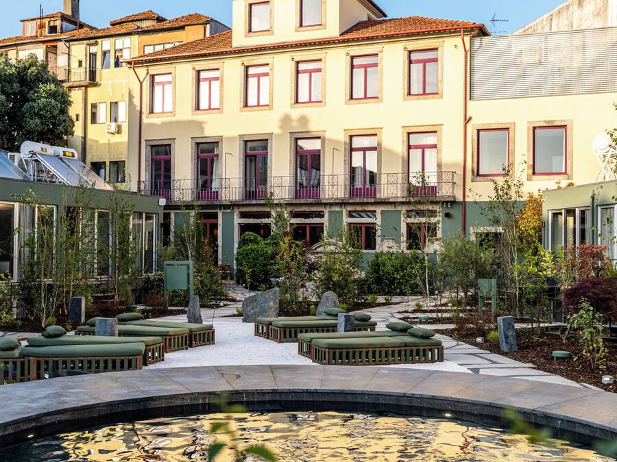 Un patio con piscina, rodeado de edificios con balcones y ventanas.
