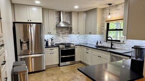 Una cocina moderna con electrodomésticos de acero inoxidable, armarios blancos y una isla grande.