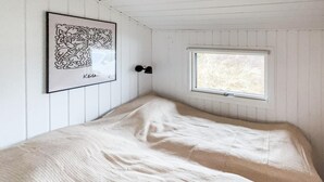 Une pièce comprenant un lit, une œuvre d’art encadrée, une fenêtre et une porte.