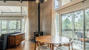 Un intérieur moderne avec une table à manger en bois, des chaises, un canapé et une cheminée.