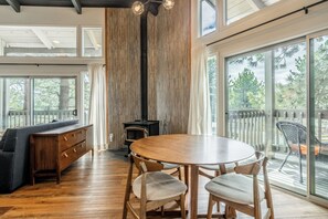 A modern interior with a wooden dining table, chairs, a sofa, and a fireplace. - Mammoth Modern Haus close to the shuttle, restaurants, and shops (Mammoth Lakes)