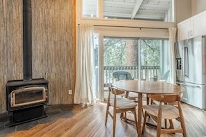 A kitchen with a built-in stove, a dining table with chairs, and a view through large windows. - Mammoth Modern Haus close to the shuttle, restaurants, and shops (Mammoth Lakes)