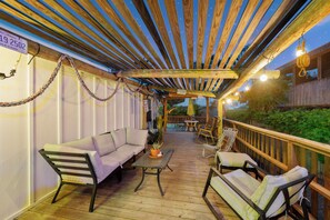 A wooden deck with a sofa, chairs, and a table. - Perfect oasis with private pool and wrap around deck! (Port Aransas)