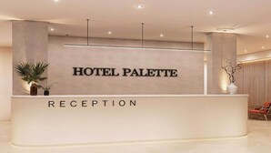 En receptionsdisk med skylten ”HOTEL PALETTE” och texten ”RECEPTION” under.