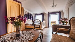 A room with a wooden table, a chair, a bed, and a window with curtains. - Luční penzion (Česká Skalice)