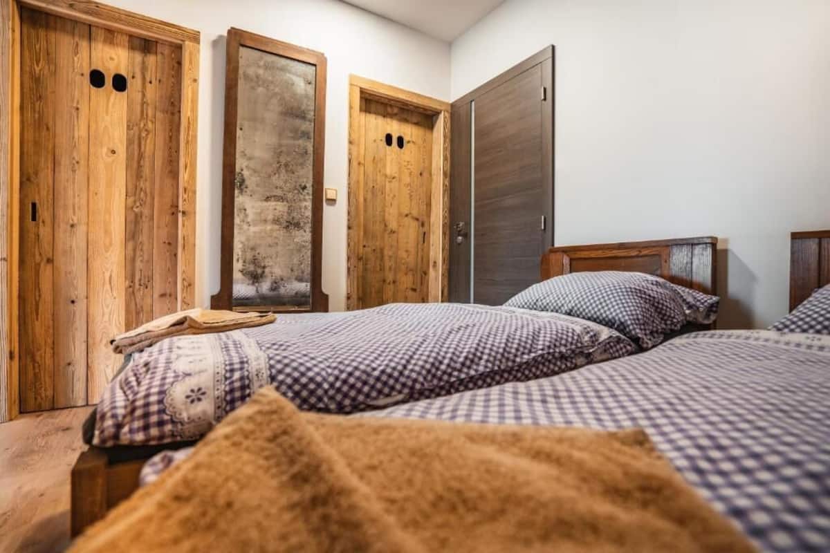 Une chambre à coucher avec un lit, deux armoires en bois et une porte.