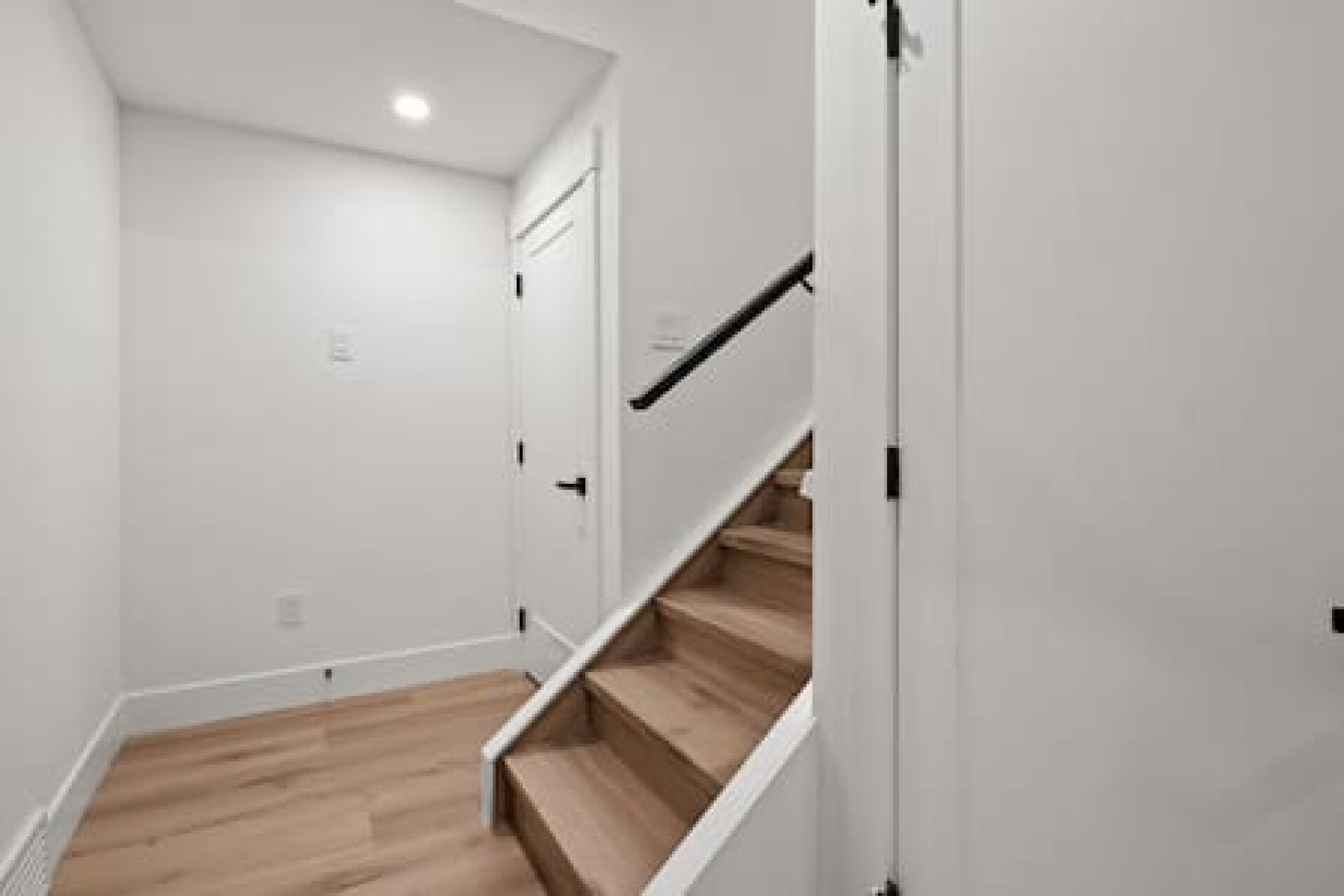 Een trap met houten treden en witte wanden.