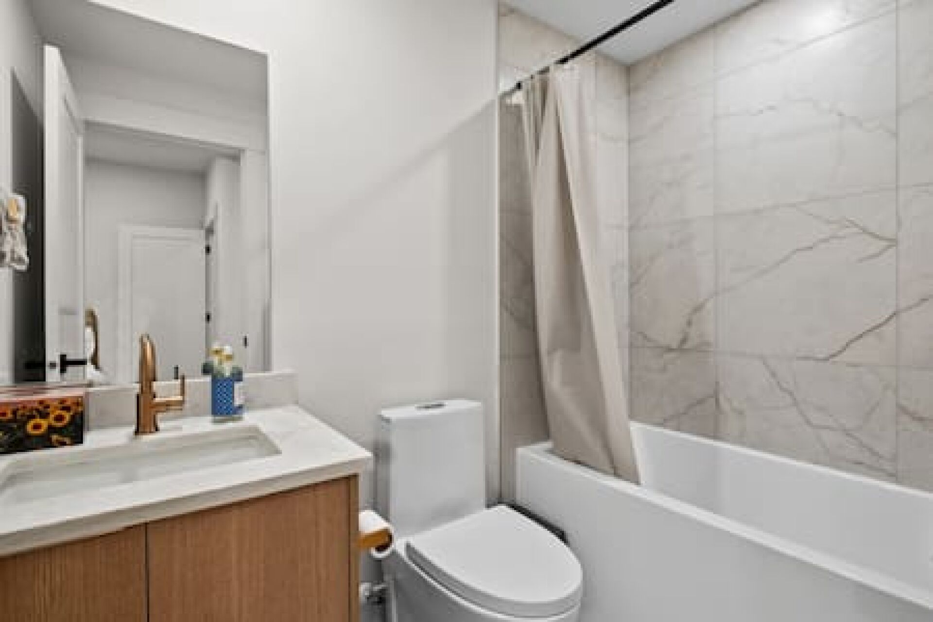 A bathroom with a toilet, sink, and bathtub.