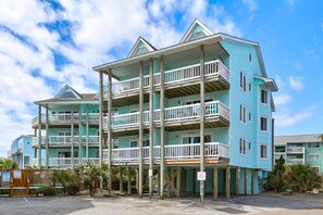 Bright turquoise beach house featuring multi-level balconies and coastal charm in a relaxed oceanside neighborhood setting. - Island North C14 - 2 Bedroom Condo with Oceanview (Carolina Beach)