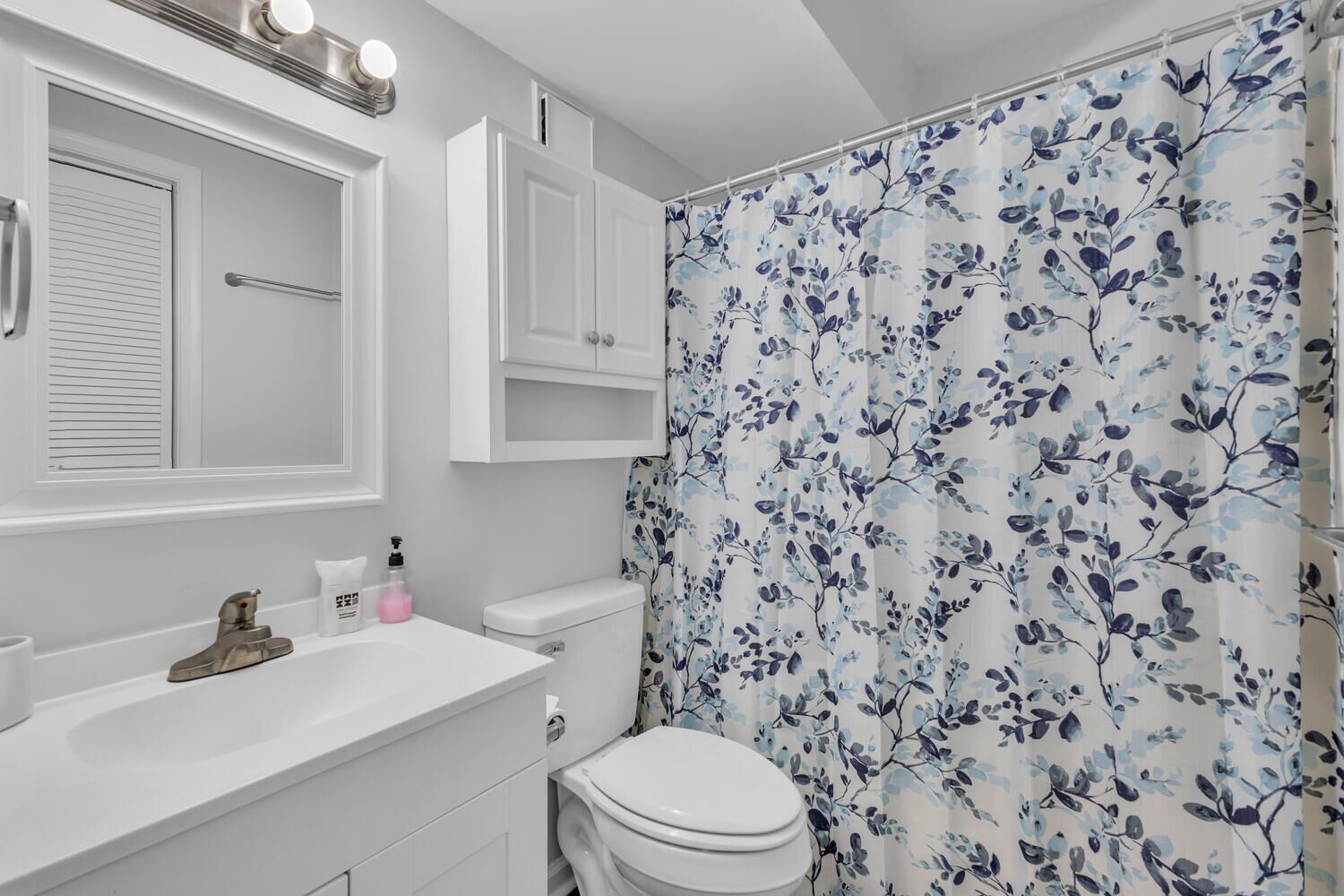 Step into your bright, cheerfully appointed bathroom featuring charming floral accents and crisp white finishes for a refreshing start to each day.