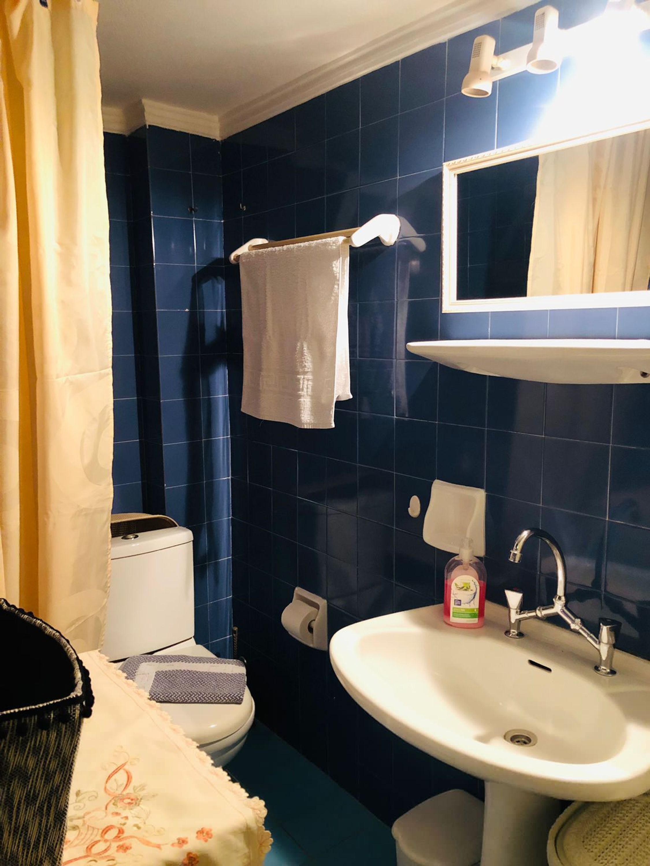 A bathroom with a toilet, sink, and towel rack.