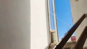 En trappe fører op til et rum med et vindue, en loftsventil og en stikkontakt på væggen.