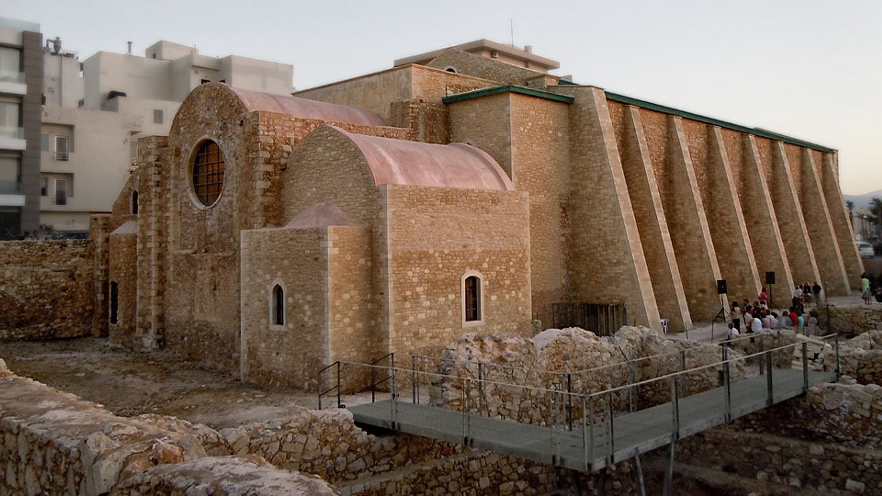 Ein altes Steinhaus mit Rundbogenfenstern und einem großen, geneigten Dach.
