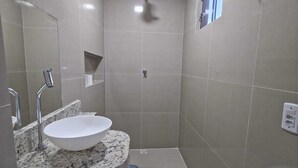 Une petite salle de bain avec un lavabo, des toilettes et une douche.