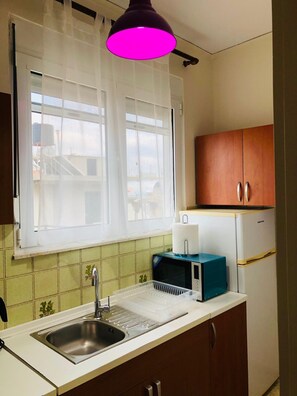 Eine Küche mit Spüle, Mikrowelle und Kühlschrank.