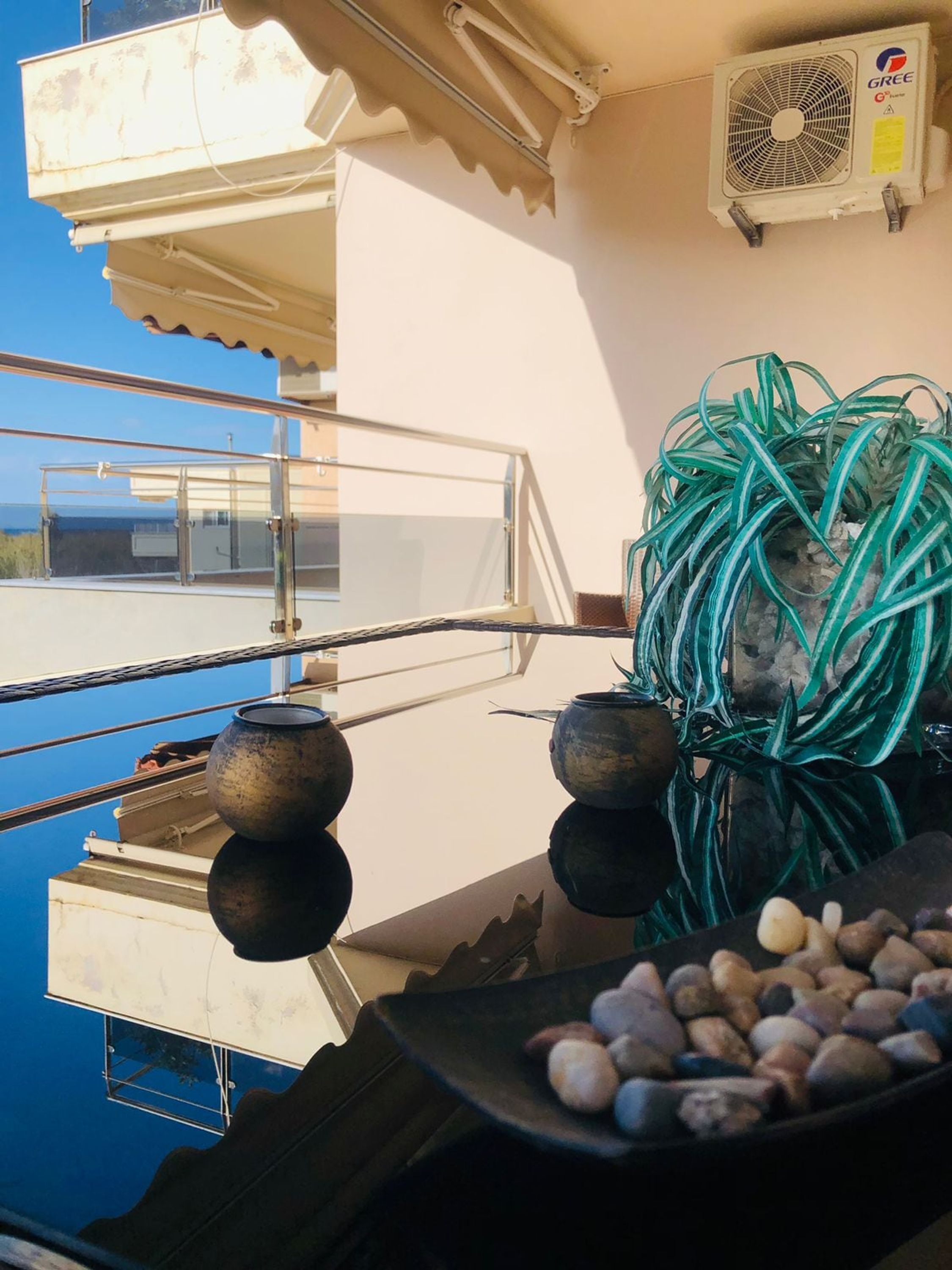 Un balcon avec vue, un ventilateur et une plante.
