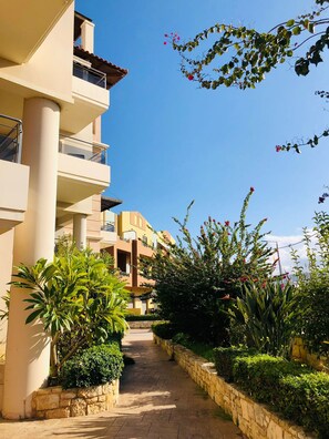 A multi-story building with balconies, a paved pathway, and lush greenery. - Ariadni s Apartment 1 in Chania City (Chania)