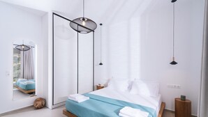 A modern bedroom with a bed, a mirror, and pendant lights. - Ramo Dolivo Villa With Private Pool (Faistos)