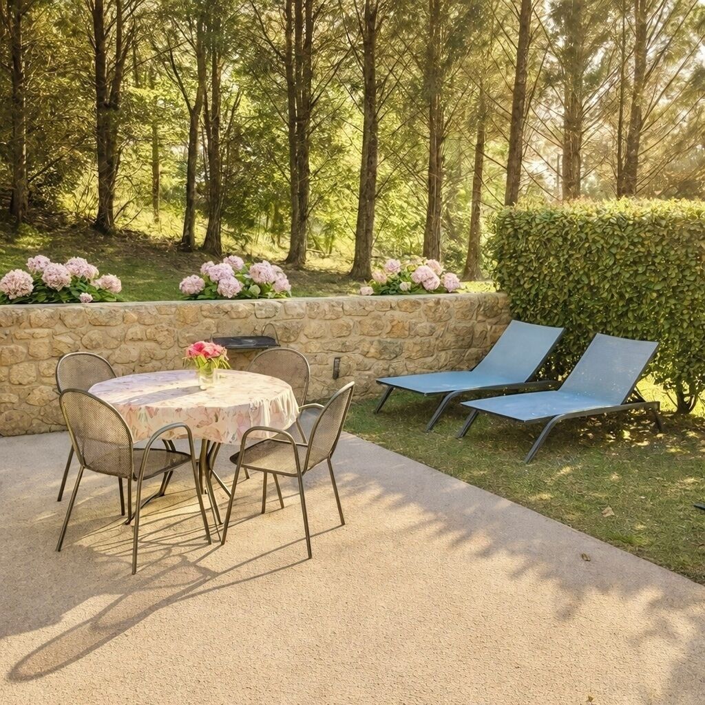 An outdoor patio with a round table, four chairs, and two lounge chairs.