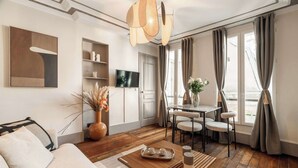 Un salon moderne comprenant un canapé, une table basse, un téléviseur et un coin repas.
