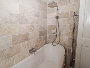 A bathroom with a freestanding bathtub, a showerhead, and a towel rack. - Pencestyll (Cardigan)