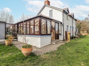 A house with a conservatory, a garden, and a gravel pathway. - Pencestyll (Cardigan)