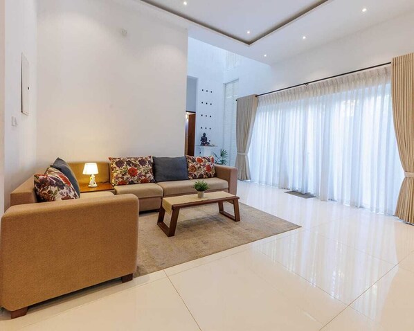 A modern living room with a sofa, coffee table, and a lamp.