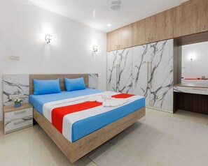 A modern bedroom with a wooden bed, marble-patterned walls, and a built-in wardrobe.