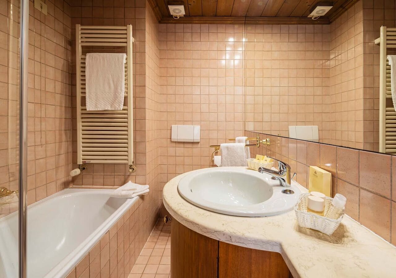 A bathroom with a bathtub, a sink, and a mirror.