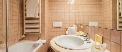 Een badkamer met een bad, een wastafel en een spiegel.