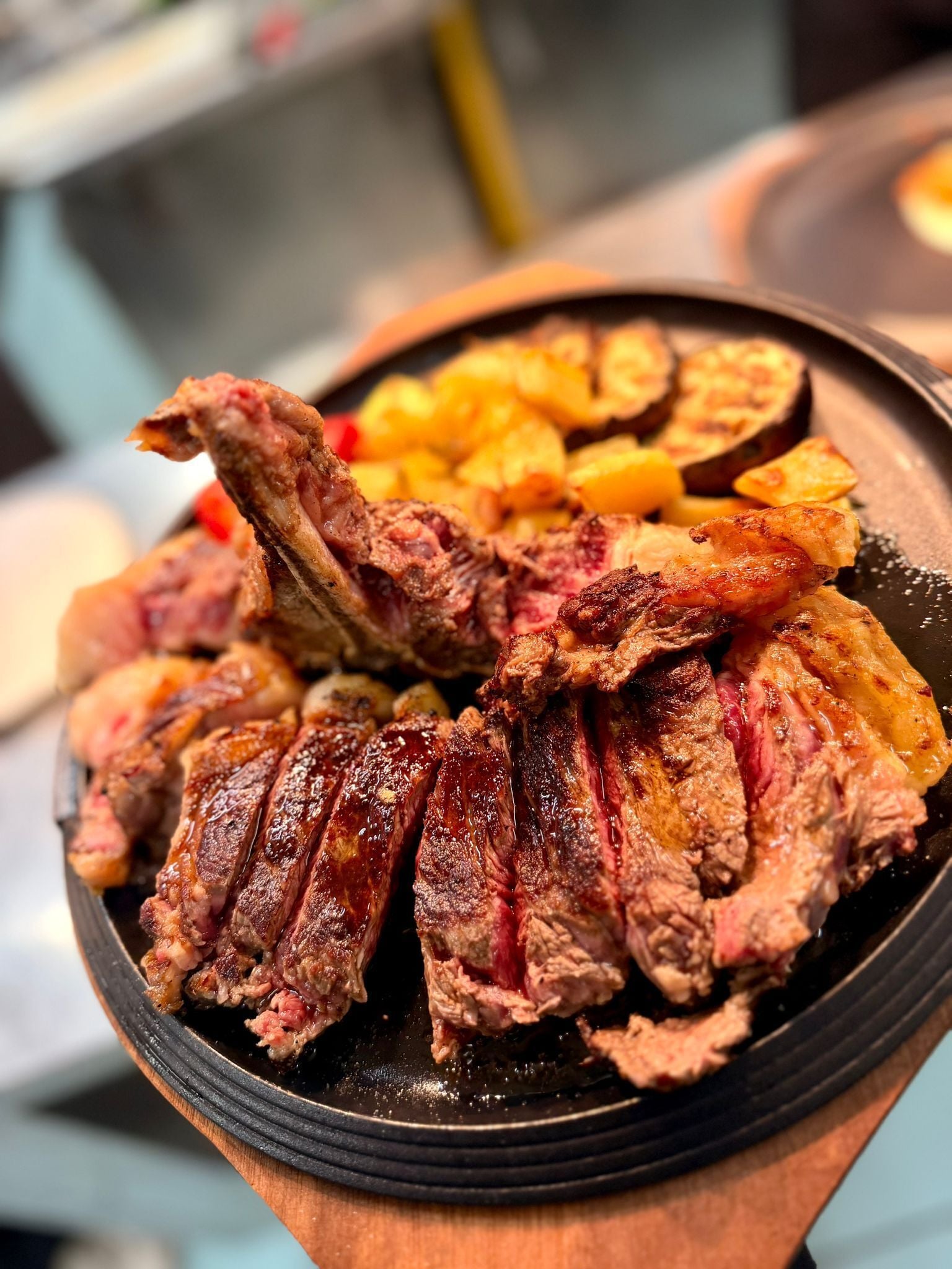 Uma tigela de carne fatiada com batatas.