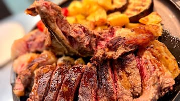 Uma tigela de carne fatiada com batatas.