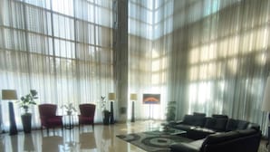 Eine großzügige Lobby mit einer großen Couch, roten Sesseln und einem Couchtisch.