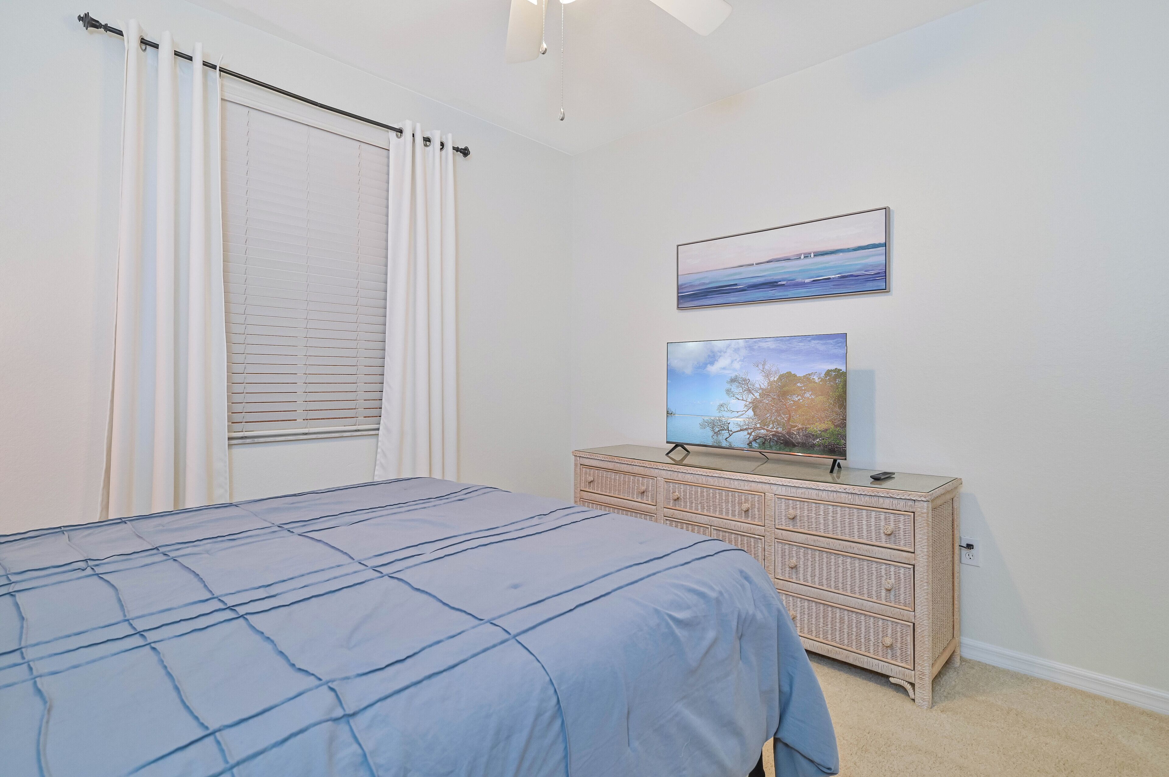 Ein Schlafzimmer mit einem Bett, einer Kommode und zwei Bildern an der Wand.