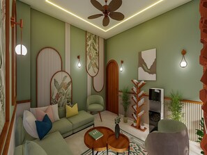 A living room with a sofa, armchairs, a coffee table, a TV, and a bookshelf. - Palette Hotel Millennium City Centre (Gurugram)