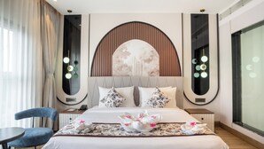 Een hotelkamer met een groot bed, een bureau, een stoel en een raam van formaat.
