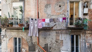 A building with visible wear and tear, balconies with plants, and clothes hanging on a line. - Cuevas Home Relais  (Naples)