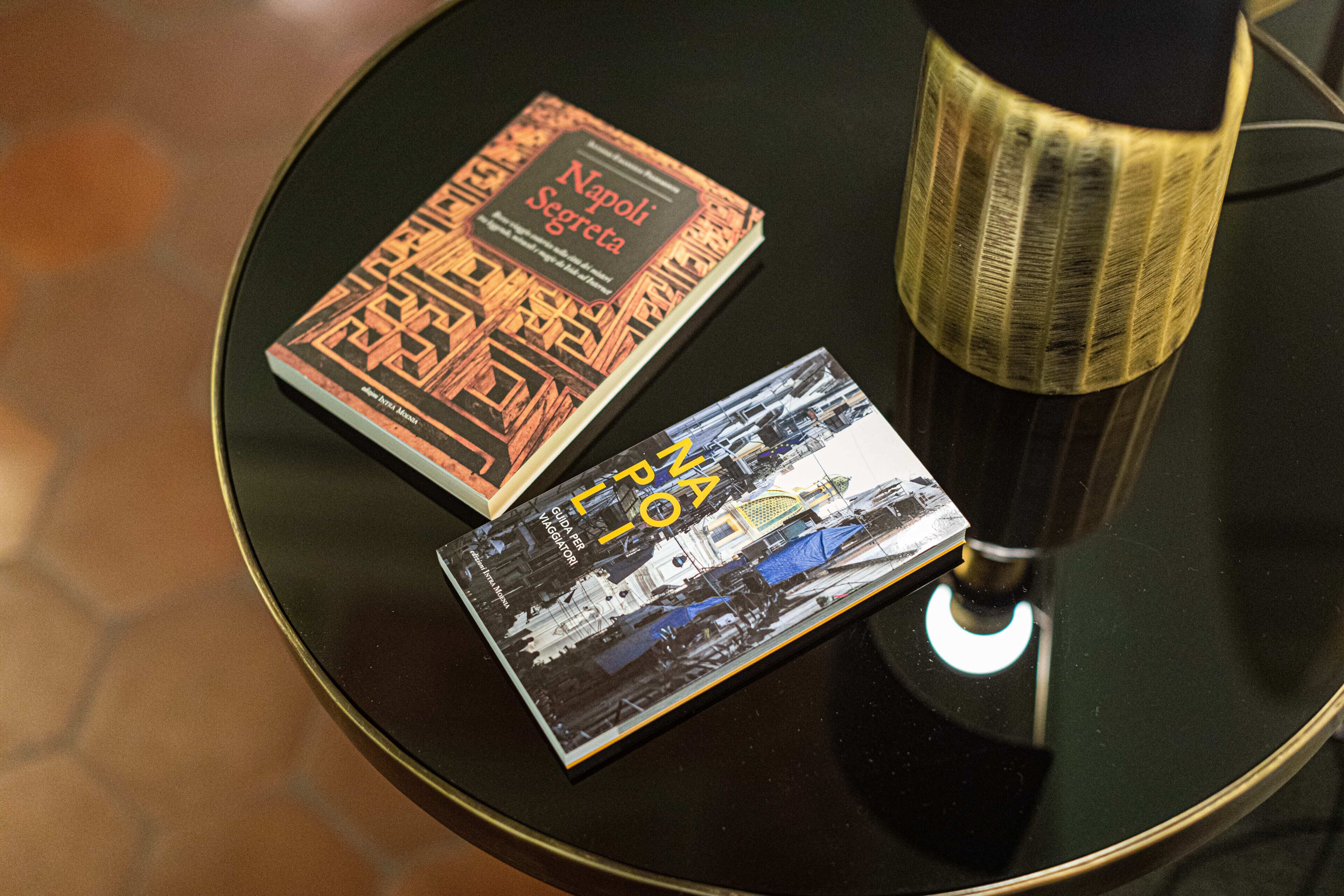 Dos libros sobre una mesa redonda con una lámpara.