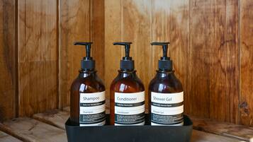 Three bottles of personal care products in a black container.