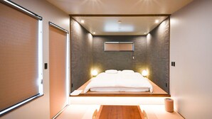 A modern hotel room with a bed, bedside table, and a small table in the center. - FOG VILLA&SPA (Kirishima)