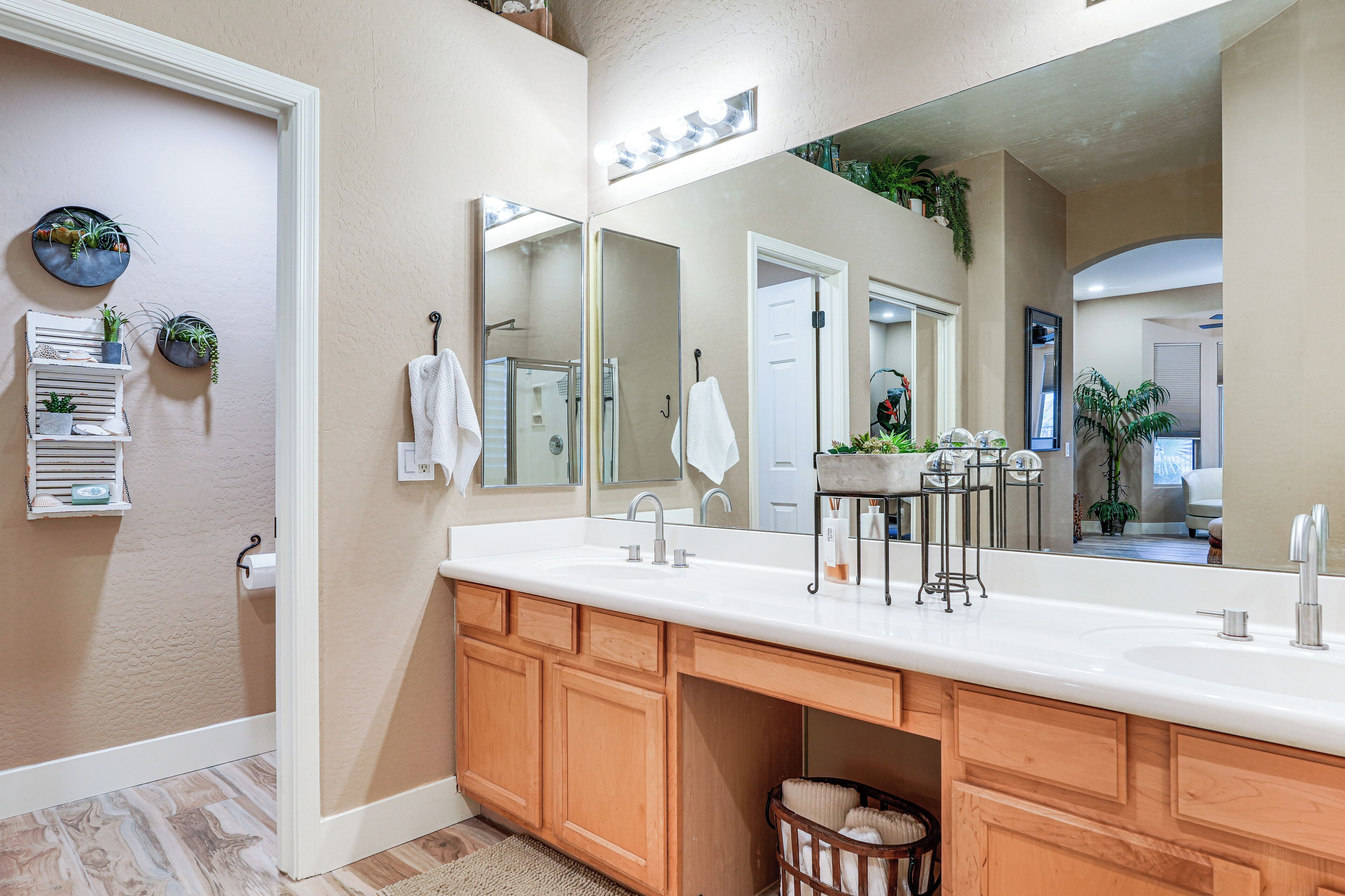 Une salle de bain avec un grand miroir, un meuble-lavabo en bois et un évier.