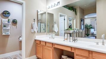 Une salle de bain avec un grand miroir, un meuble-lavabo en bois et un évier.