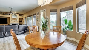 A dining area with a wooden table, chairs, and a potted plant. - Patio & Home Gym! Augusta Ranch Golf Home (Mesa)