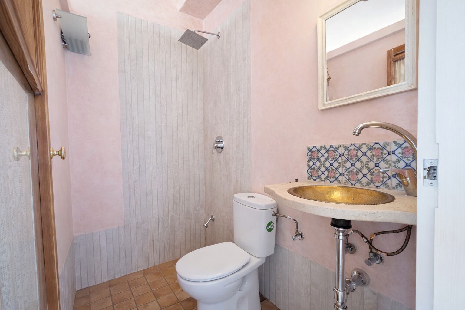 Un baño con ducha, inodoro, lavabo y espejo.