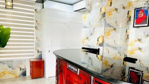 A reception desk with a 'RECEPTION' sign, a marble-patterned wall, and a potted plant.