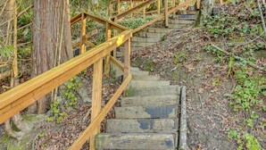 A wooden staircase with a handrail, surrounded by trees and foliage. - Walk to Beach! Scenic 'wine Studio' in Gig Harbor (Gig Harbor)