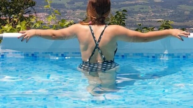 A person in a pool with a view of a landscape. - Casas Da Ribeira (Seia)